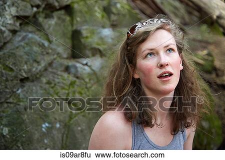 Young woman standing in front of rock wall View Large Photo Image Stock Photograph - Young woman standing in front of rock wall. Fotosearch