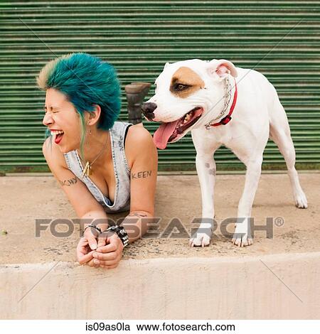 Young woman with colourful hair, lying on floor next to dog, laughing View Large Photo Image Stock Image - Young woman with colourful hair, lying on floor next to dog, laughing. Fotosearch