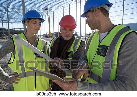 Architect and builders using digital tablet on construction site View Large Photo Image Stock Image - Architect and builders using digital tablet on construction site. Fotosearch