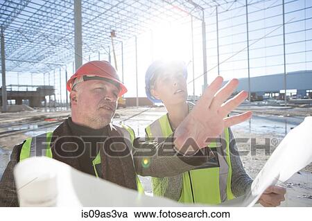 Architect explaining to builder on construction site View Large Photo Image Stock Image - Architect explaining to builder on construction site. Fotosearch
