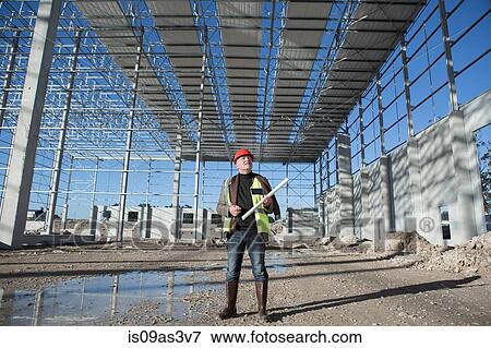 Architect looking up at construction frame View Large Photo Image Stock Photo - Architect looking up at construction frame. Fotosearch