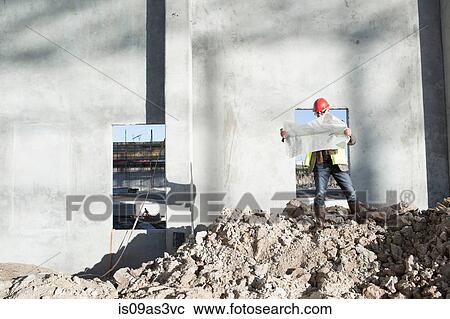 Architect reviewing blueprint on construction site View Large Photo Image Stock Image - Architect reviewing blueprint on construction site. Fotosearch