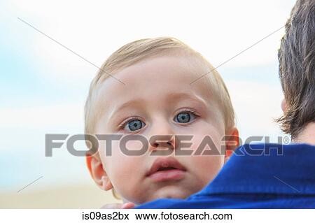 Baby boy looking over father's shoulder View Large Photo Image Stock Photo - Baby boy looking over father's shoulder. Fotosearch