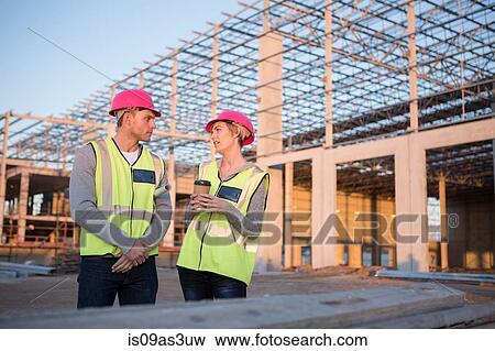 Stock Photo - Builder and architect having coffee break meeting on construction site. Fotosearch