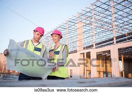 Builder and architect looking at blueprint on construction site View Large Photo Image Stock Photo - Builder and architect looking at blueprint on construction site. Fotosearch