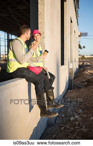 Stock Photograph - Builder and architect taking a coffee break on construction site. Fotosearch