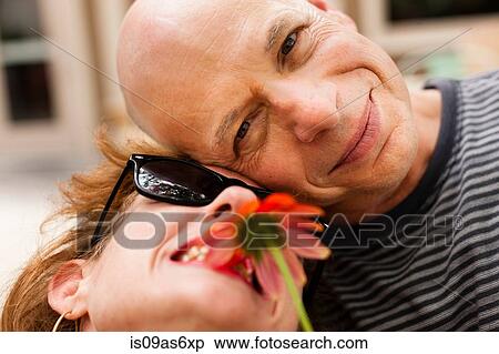 Close up portrait of smiling couple with red flower View Large Photo Image Stock Photography - Close up portrait of smiling couple with red flower. Fotosearch
