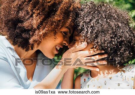 Stock Image - Close up side view of mother and daughter nose to nose. Fotosearch
