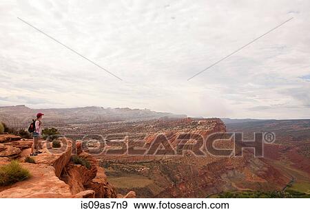 Stock Photo - Female hiker looking out over Capitol Reef National Park, Torrey, Utah, USA. Fotosearch