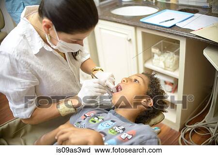 Female orthodontist examining boy in dental surgery View Large Photo Image Stock Image - Female orthodontist examining boy in dental surgery. Fotosearch