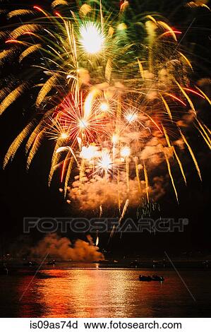 Stock Image - Fireworks exploding over water, Bainbridge Island, Washington, USA. Fotosearch