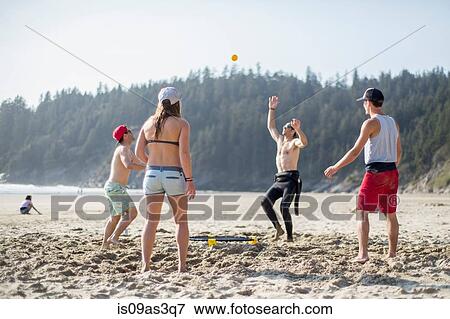 Four adult friends throwing and catching ball on Short Sands Beach, Oregon, USA View Large Photo Image Stock Photo - Four adult friends throwing and catching ball on Short Sands Beach, Oregon, USA. Fotosearch