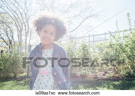 Front view of girl in sunlight, hands behind back, looking at camera smiling View Large Photo Image Stock Image - Front view of girl in sunlight, hands behind back, looking at camera smiling. Fotosearch
