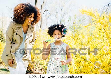 Front view of mother and daughter blowing bubbles View Large Photo Image Stock Photography - Front view of mother and daughter blowing bubbles. Fotosearch