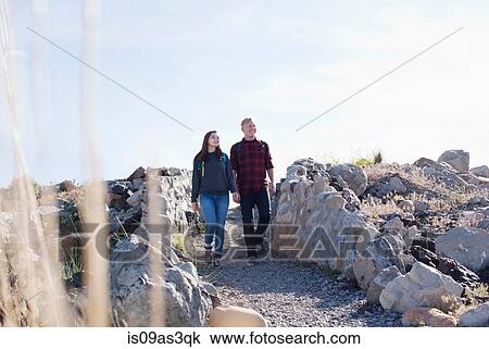 Full length front view of young couple holding hands walking, looking away View Large Photo Image Stock Image - Full length front view of young couple holding hands walking, looking away. Fotosearch