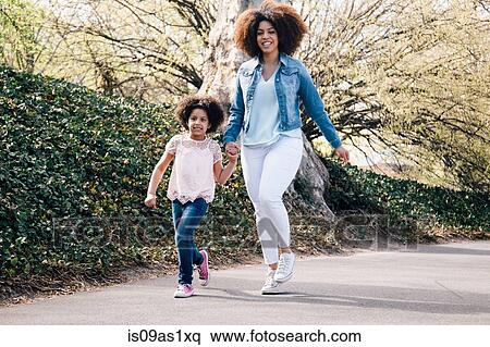 Full length shot of mother and daughter holding hands walking along path smiling View Large Photo Image Stock Photography - Full length shot of mother and daughter holding hands walking along path smiling. Fotosearch