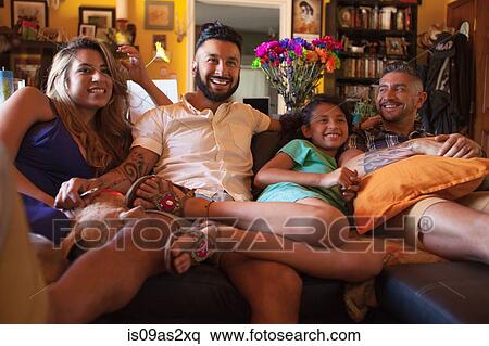 Girl and family watching TV on living room sofa View Large Photo Image Stock Photography - Girl and family watching TV on living room sofa. Fotosearch