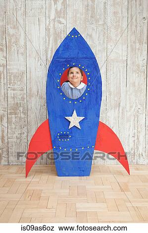 Girl looking up from window of blue homemade cardboard rocket View Large Photo Image Stock Photo - Girl looking up from window of blue homemade cardboard rocket. Fotosearch