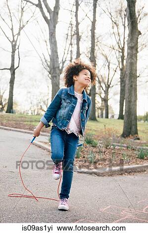 Girl standing on one leg, playing with skipping rope, looking up View Large Photo Image Stock Image - Girl standing on one leg, playing with skipping rope, looking up. Fotosearch