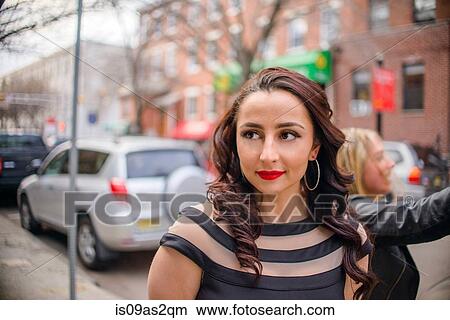 Picture - Glamorous young woman walking along street. Fotosearch
