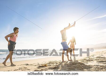 Group of friends fooling around on beach View Large Photo Image Stock Image - Group of friends fooling around on beach. Fotosearch
