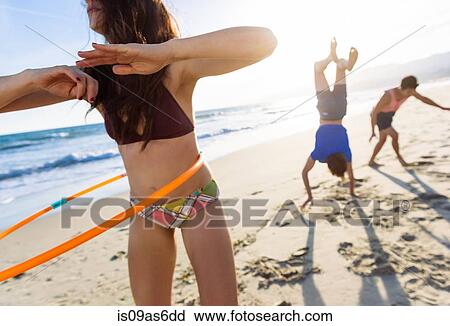 Stock Image - Group of friends fooling around on beach. Fotosearch