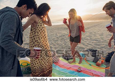 Group of friends having party on beach, at sunset View Large Photo Image Picture - Group of friends having party on beach, at sunset. Fotosearch