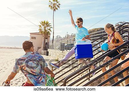 Group of friends heading towards beach, ready for picnic View Large Photo Image Stock Image - Group of friends heading towards beach, ready for picnic. Fotosearch