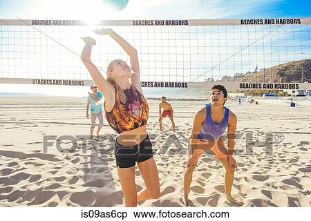 Stock Photography - Group of friends playing volleyball on beach. Fotosearch