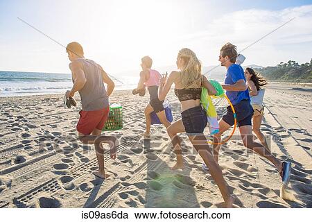 Group of friends running on beach, rear view View Large Photo Image Stock Image - Group of friends running on beach, rear view. Fotosearch