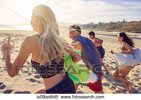 Group of friends running on beach, rear view View Large Photo Image Stock Photography - Group of friends running on beach, rear view. Fotosearch