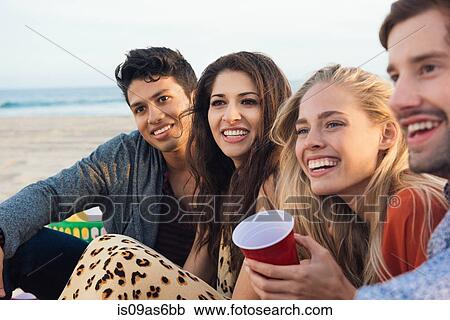 Group of friends sitting together on beach View Large Photo Image Stock Image - Group of friends sitting together on beach. Fotosearch