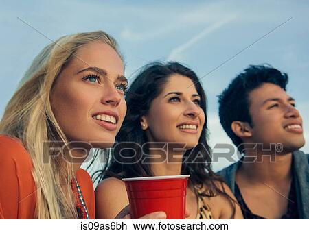 Group of friends sitting together outdoors View Large Photo Image Stock Image - Group of friends sitting together outdoors. Fotosearch