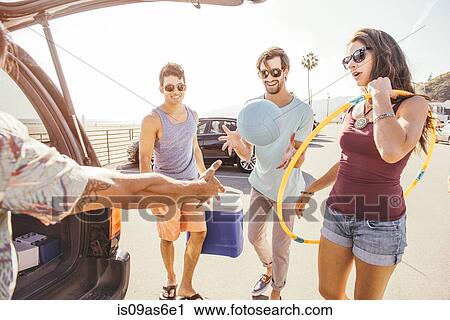 Group of friends standing by car, holding picnic and play items View Large Photo Image Stock Image - Group of friends standing by car, holding picnic and play items. Fotosearch