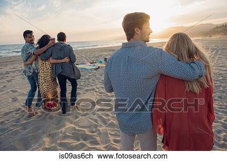 Group of friends standing on beach, hugging, rear view View Large Photo Image Stock Image - Group of friends standing on beach, hugging, rear view. Fotosearch