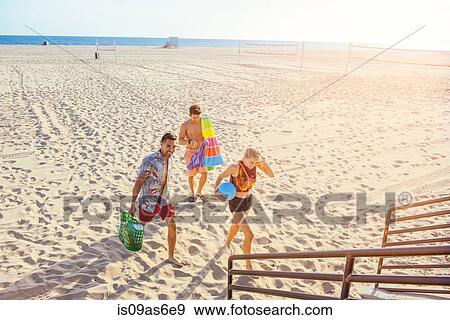Stock Photo - Group of friends walking away from beach. Fotosearch