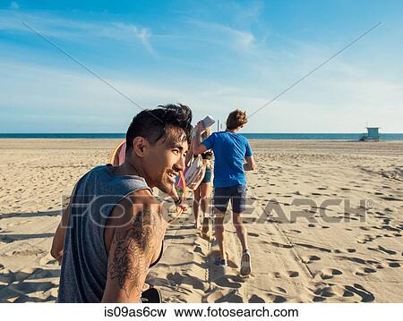 Group of friends walking on beach, rear view View Large Photo Image Stock Photo - Group of friends walking on beach, rear view. Fotosearch