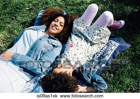 High angle view of mother and daughter lying side by side on backs, eyes closed View Large Photo Image Stock Image - High angle view of mother and daughter lying side by side on backs, eyes closed. Fotosearch