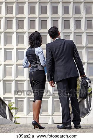 Stock Image - Low angle full length view of business people, looking up. Fotosearch