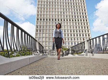 Stock Photo - Low angle view of business woman carrying briefcase. Fotosearch