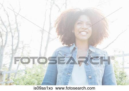 Low angle view portrait of mid adult woman in sunlight, smiling looking away View Large Photo Image Picture - Low angle view portrait of mid adult woman in sunlight, smiling looking away. Fotosearch