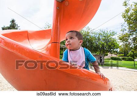 Male toddler climbing up orange playground slide View Large Photo Image Stock Image - Male toddler climbing up orange playground slide. Fotosearch