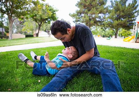 Male toddler playing with older adult brother in park View Large Photo Image Picture - Male toddler playing with older adult brother in park. Fotosearch