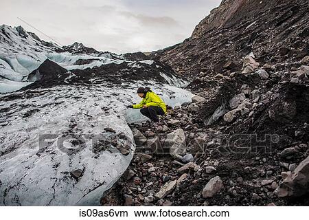 Male tourist examining glacier at Solheimajokull, Iceland View Large Photo Image Picture - Male tourist examining glacier at Solheimajokull, Iceland. Fotosearch