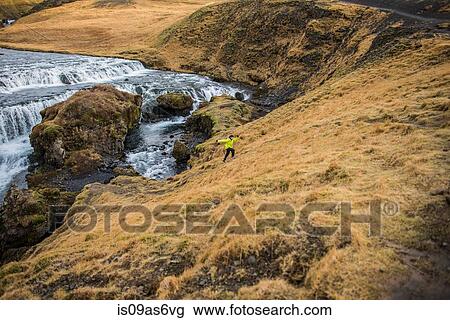 Male tourist running up hill at Skogafoss, Iceland View Large Photo Image Stock Image - Male tourist running up hill at Skogafoss, Iceland. Fotosearch