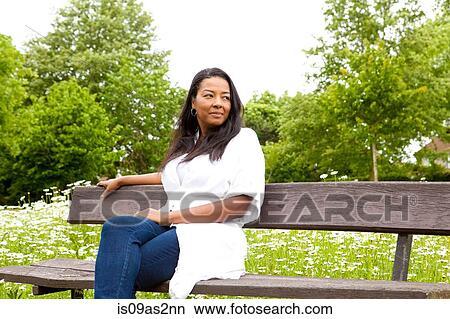 Picture - Mature woman looking out from park bench. Fotosearch