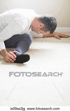 Stock Image - Mid adult man in yoga position. Fotosearch