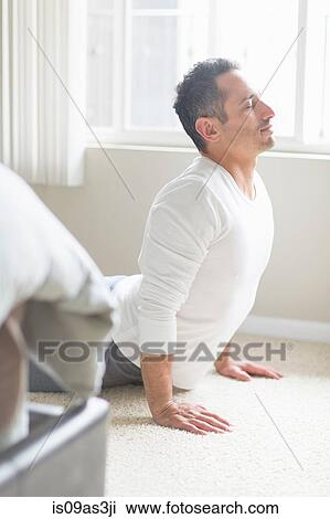 Stock Image - Mid adult man in yoga position. Fotosearch