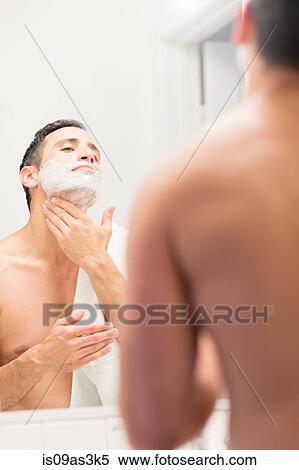 Mid adult man, looking in mirror, applying shaving foam to neck, rear view View Large Photo Image Stock Photography - Mid adult man, looking in mirror, applying shaving foam to neck, rear view. Fotosearch
