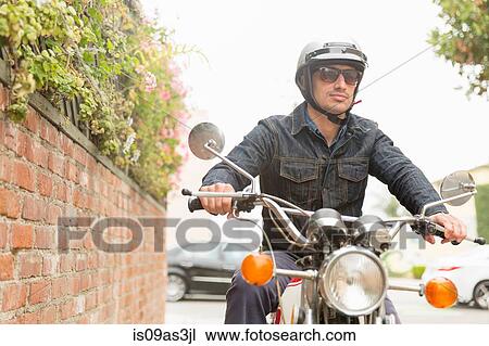 Mid adult man riding motorbike View Large Photo Image Stock Image - Mid adult man riding motorbike. Fotosearch